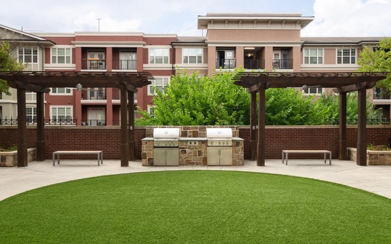 a building with a green lawn and grills