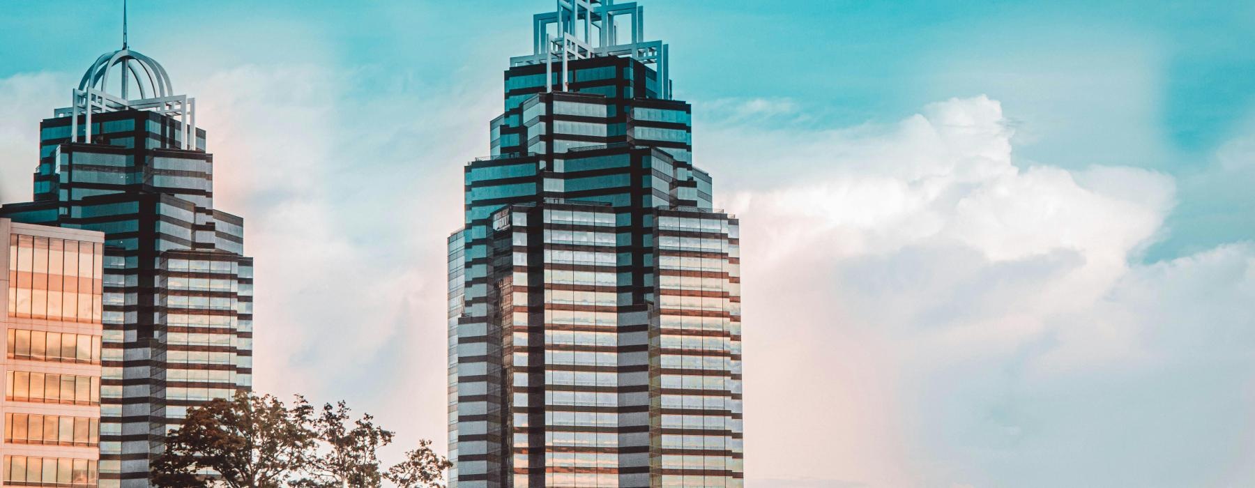 tall buildings with trees in front of it